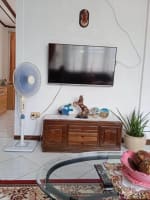 Entertainment area with television, wooden console, and glass coffee table in a house for sale in Catarman, Cordova, Cebu.