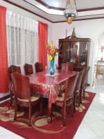 Dining room with wooden dining table, chairs, and red curtains in a furnished house for sale in Buagson, Catarman, Cordova, Cebu.