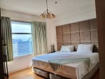 Bedroom with a queen-size bed, padded headboard, bedside tables, and floor-to-ceiling windows overlooking Cebu City at Park Point Residences.