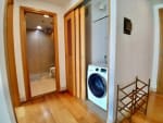 Condo hallway with a front door, full-length mirror, and stacked washer and dryer in a fully furnished 1-bedroom unit at Park Point Residences, Cebu.