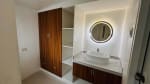Bathroom vanity with round mirror, white vessel sink, wooden cabinetry, and modern finishes in a bungalow in St. Joseph Heights, Liloan, Cebu.