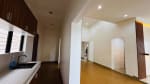 Kitchen and living area with built-in kitchen cabinetry, countertop, tiled flooring, and an open interior layout in a modern bungalow for sale in Yati, Cebu.
