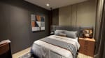Bedroom with a double bed, gray upholstered headboard, striped bedding, bedside tables, and abstract wall art in a modern house for sale in Cebu City.