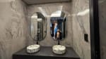 Double-sink bathroom vanity with round mirrors, stone countertop, and decorative lighting in a contemporary three-storey house for sale in Cebu City.