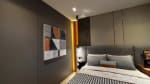 Modern bedroom with a gray upholstered bed, striped bedding, abstract wall art, and warm accent lighting in a Cebu City residential property.