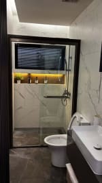 Bathroom with a glass-enclosed shower, wall-mounted shower fixtures, white toilet, and floating vanity in a contemporary Cebu City house.