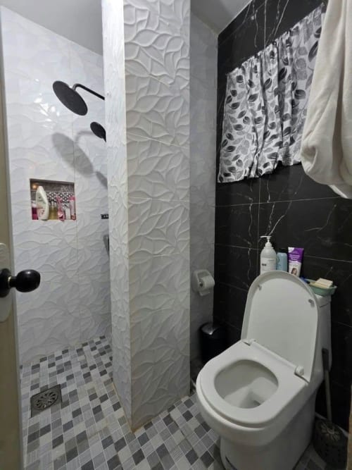Modern bathroom with toilet and black wall tiles house and lot for sale in Tisa
