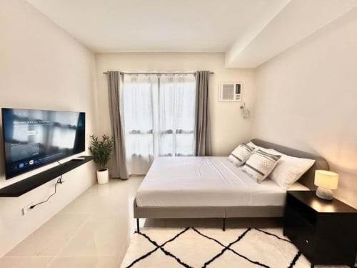 Studio bedroom with double bed, smart TV, dining area and kitchen at JTower Residences Mandaue City