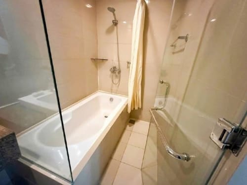 The Alcoves condo bathroom with glass shower enclosure and bathtub in Cebu City