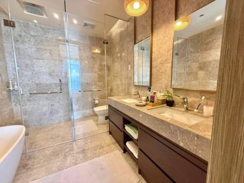 Modern bathroom vanity with countertop sink, large mirror, and stone finishes in a luxury condo at Sheraton Cebu Mactan Resort, Cebu.