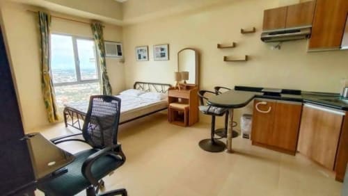 Studio condo interior with dining table, office chair, bed, and compact kitchen at Avida Riala Tower 3 in Cebu IT Park.