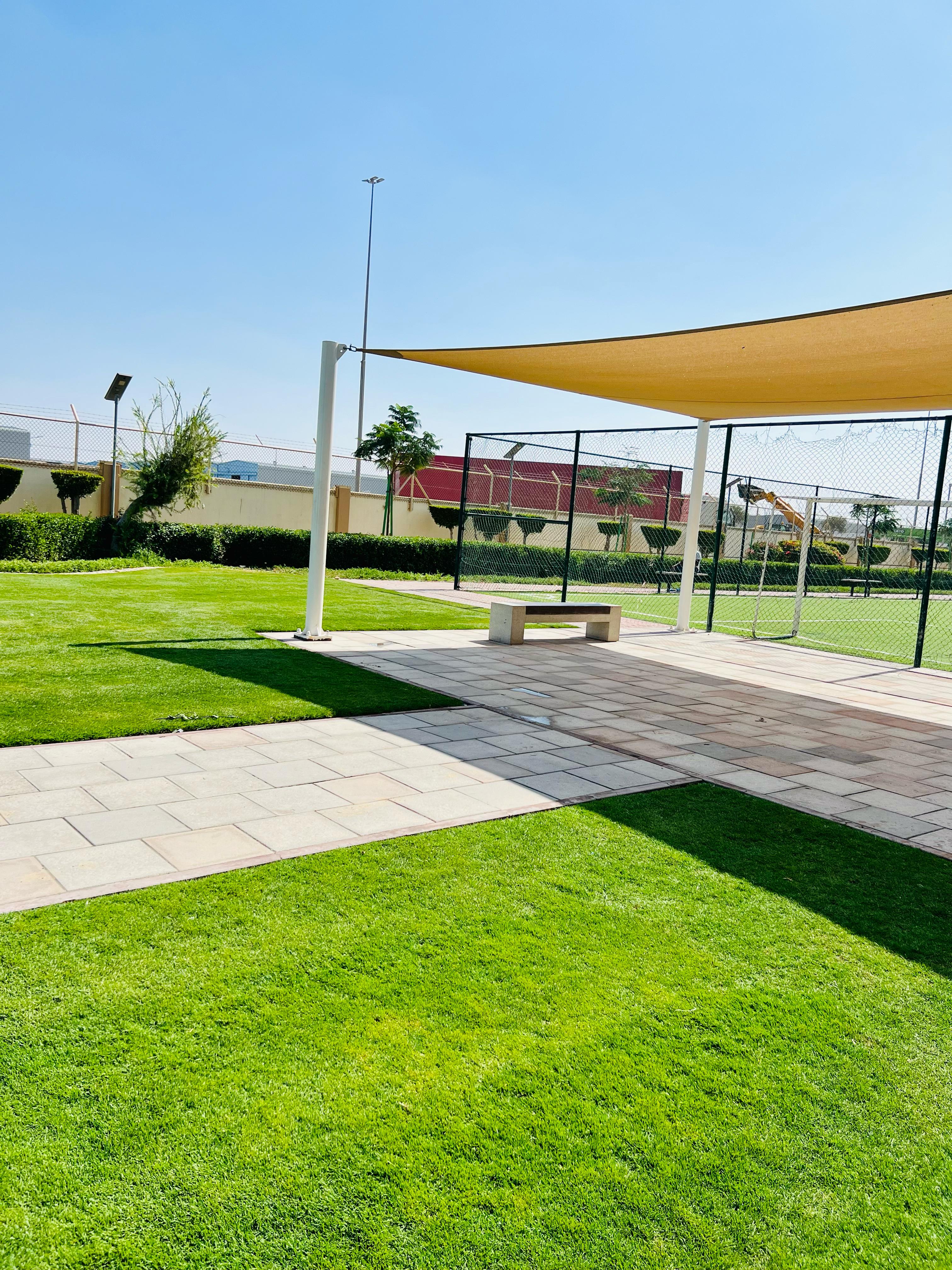 Landscape installation and hardscape works at Labour Village 2 Dubai Industrial City including interlock paving, pergola, and seating areas - Photo 7