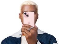 En person som håller en iPhone 15 framför sig för att dölja sin identitet.
