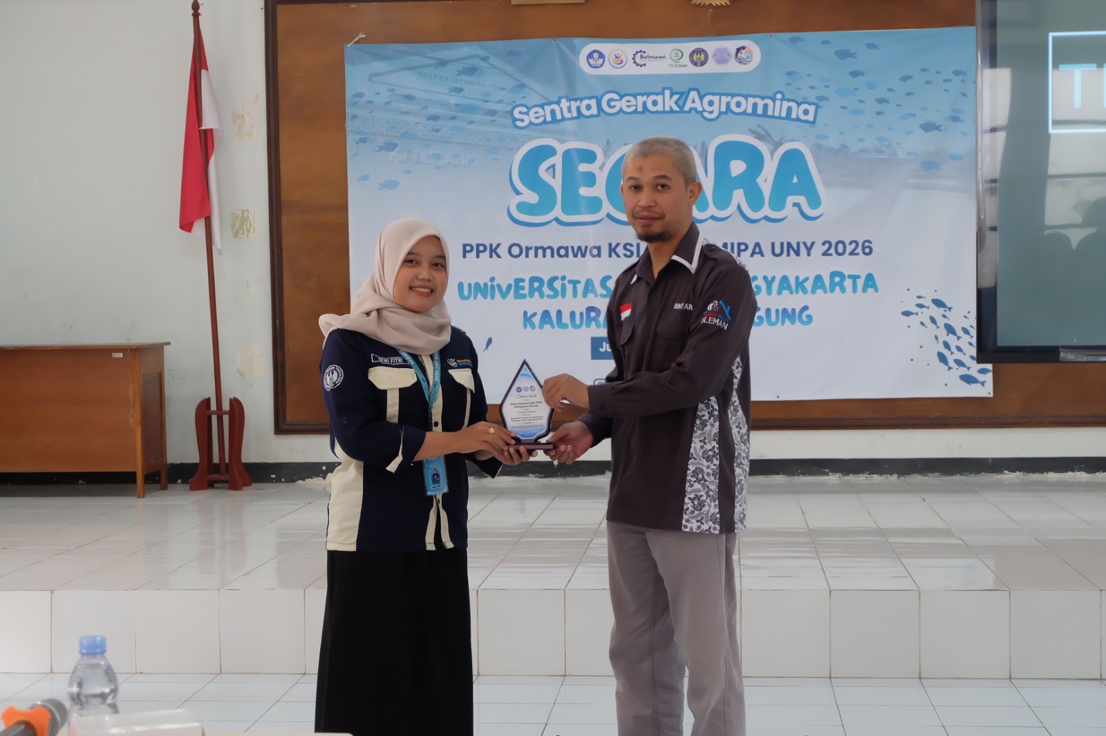 Tim PPKO KSI MIST FMIPA UNY menyerahkan plakat kepada Achmad Muzaki Bintar, C, SE., sebagai bentuk apresiasi atas keterlibatannya sebagai narasumber dalam kegiatan penguatan literasi dan manajemen keuangan usaha. (sumber dokumentasi pribadi)<div data-empty="true"><br></div><div data-empty="true"><br></div>