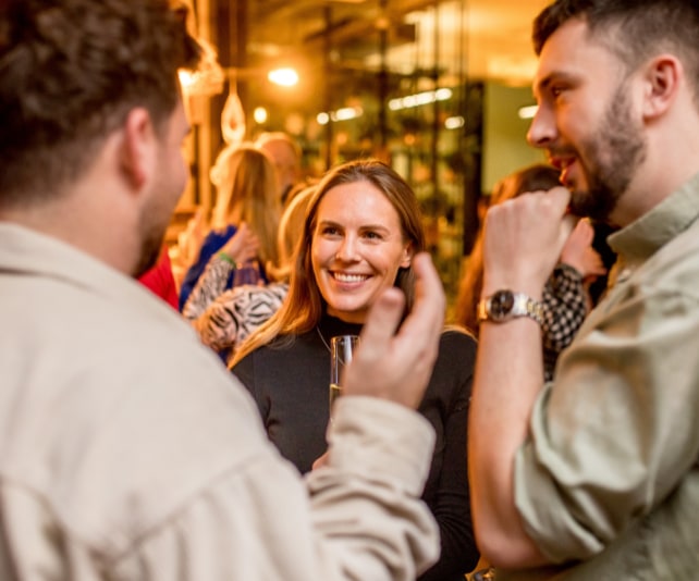 Three people chatting at a networking event.
