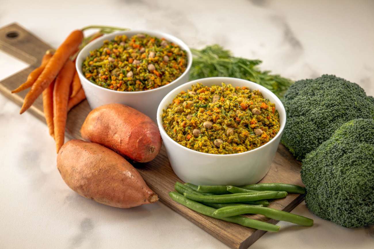 A plate of food next to a bowl of vegetables and a bowl of rice