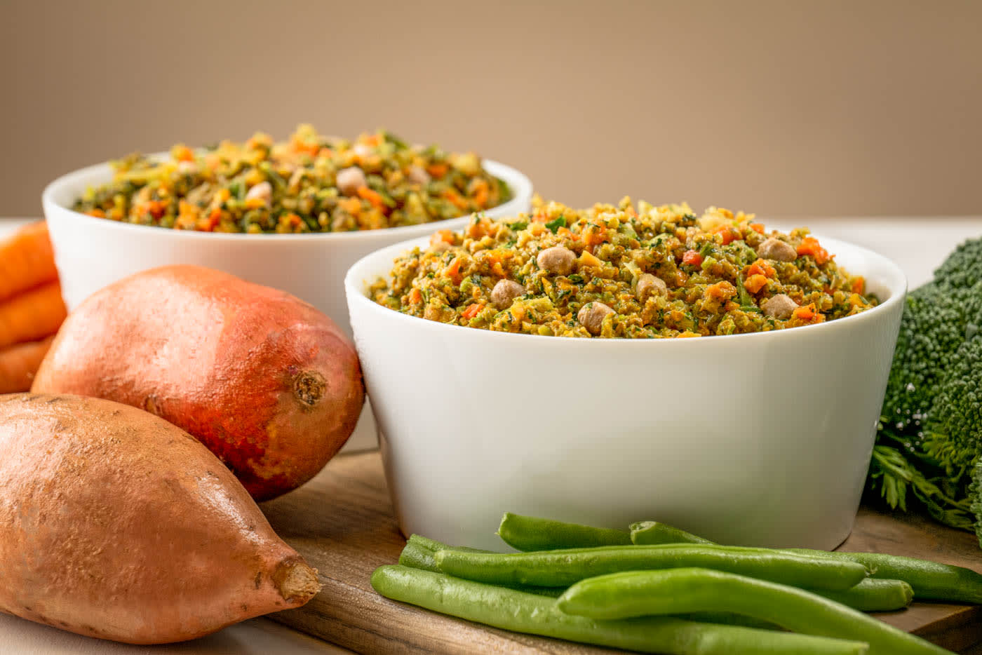 A bowl of rice and meat next to a bowl of vegetables