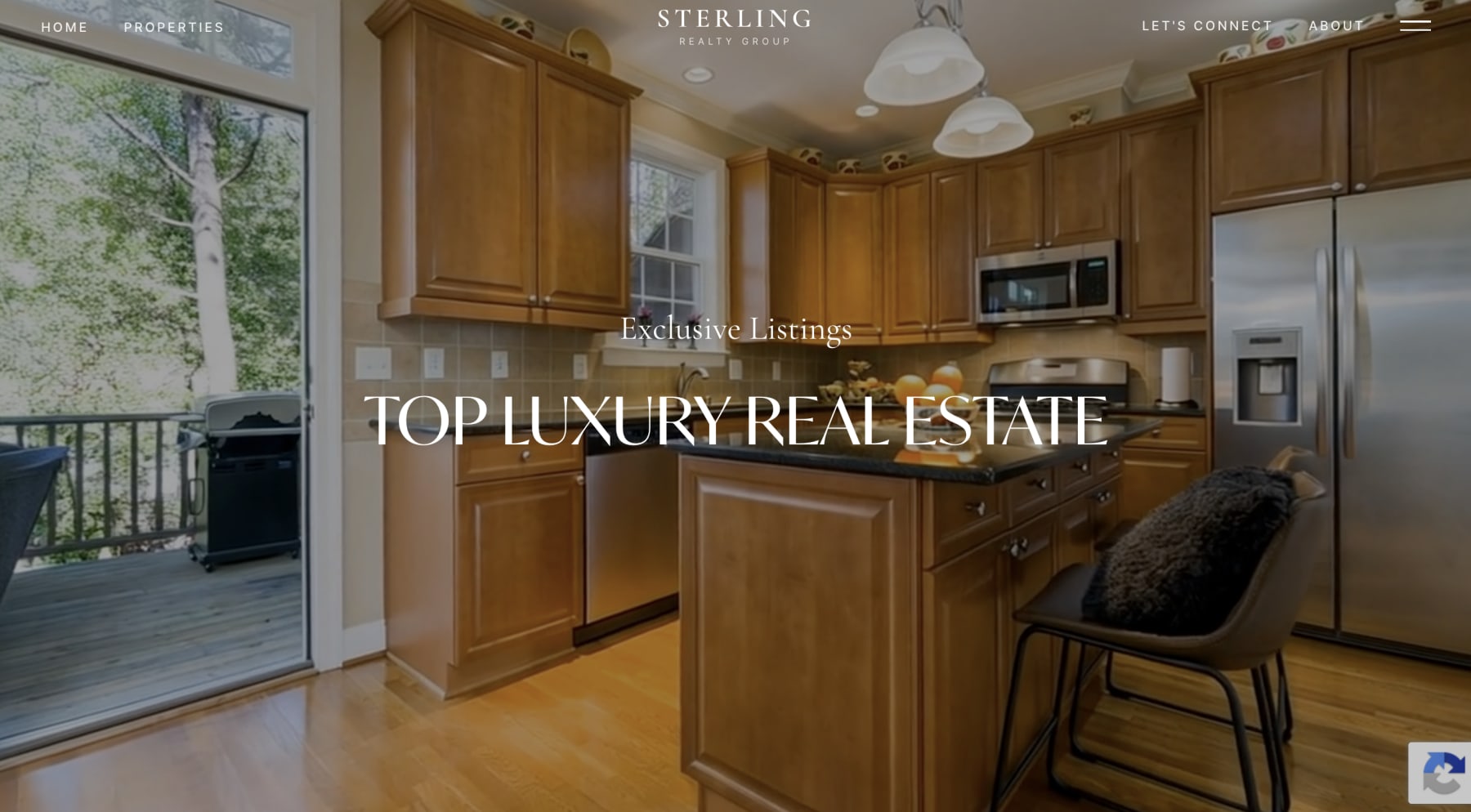 Signature theme homepage: a warm-toned kitchen fills the screen behind the Sterling Realty Group wordmark, with Exclusive Listings and Top Luxury Real Estate set in serif type over it