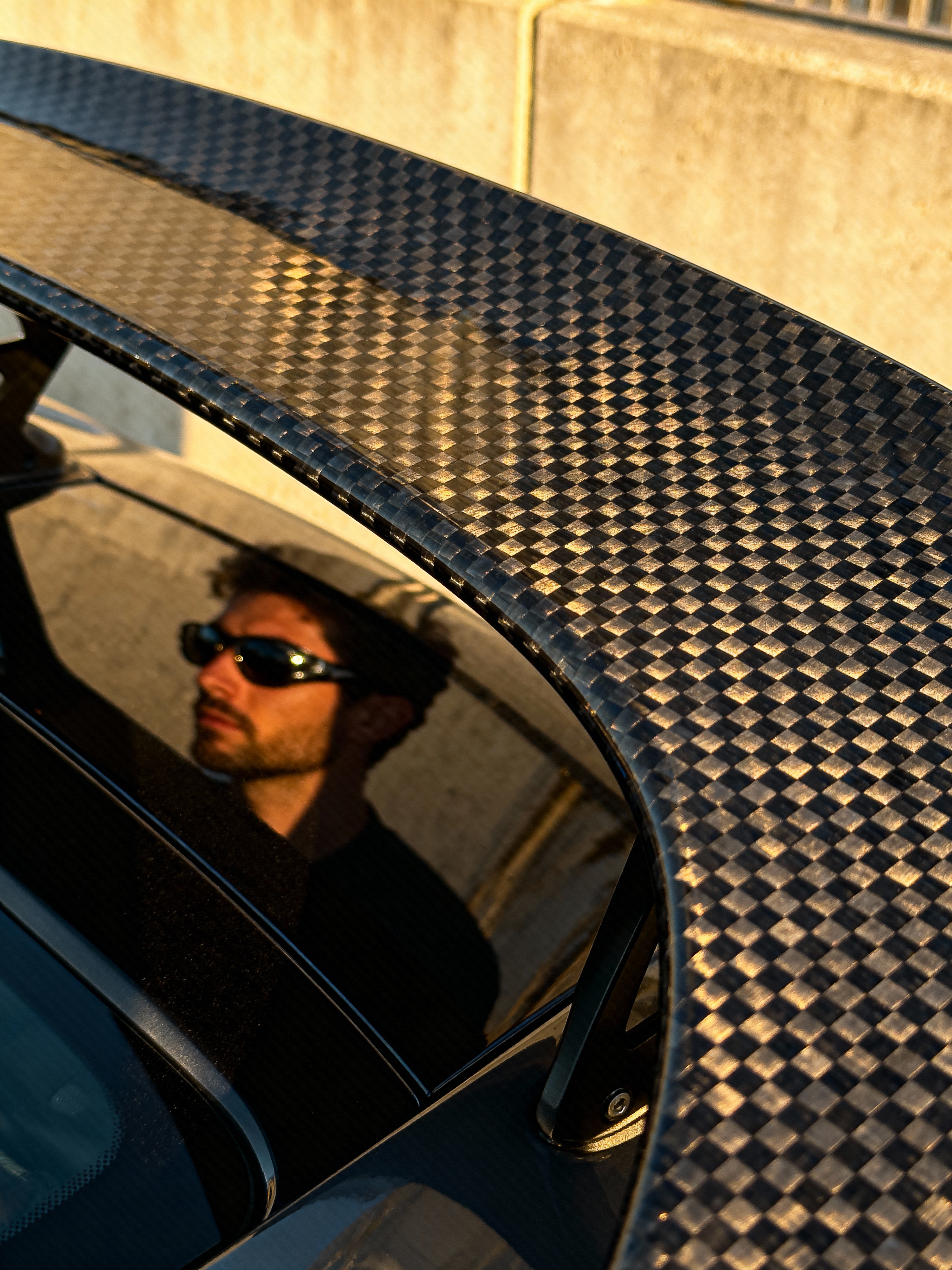 Macro shot of a supercar's carbon fiber weave.
