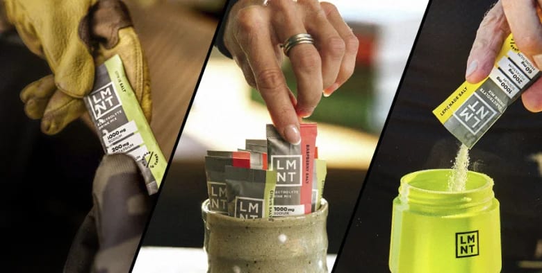 LMNT electrolyte drink mix packets in orange, watermelon, and citrus salt flavors, held in hand against black background.
