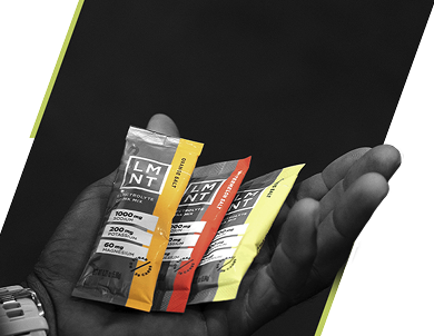 LMNT electrolyte drink mix packets in orange, watermelon, and citrus salt flavors, held in hand against black background.