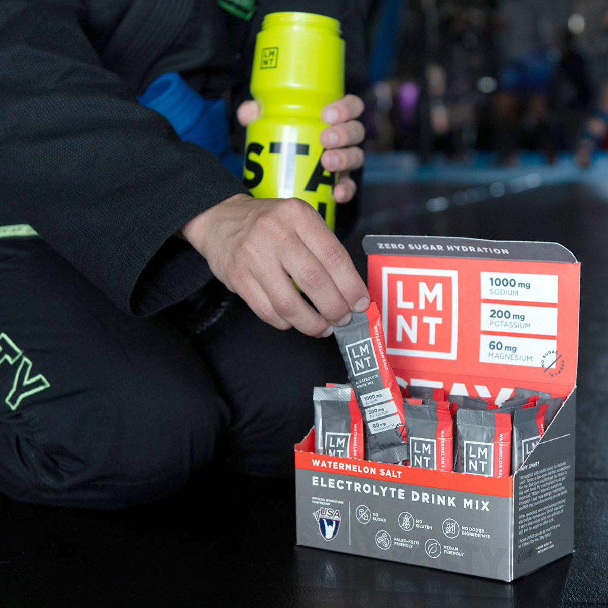 Hand selecting a LMNT electrolyte packet from a retail box containing only Grapefruit packets