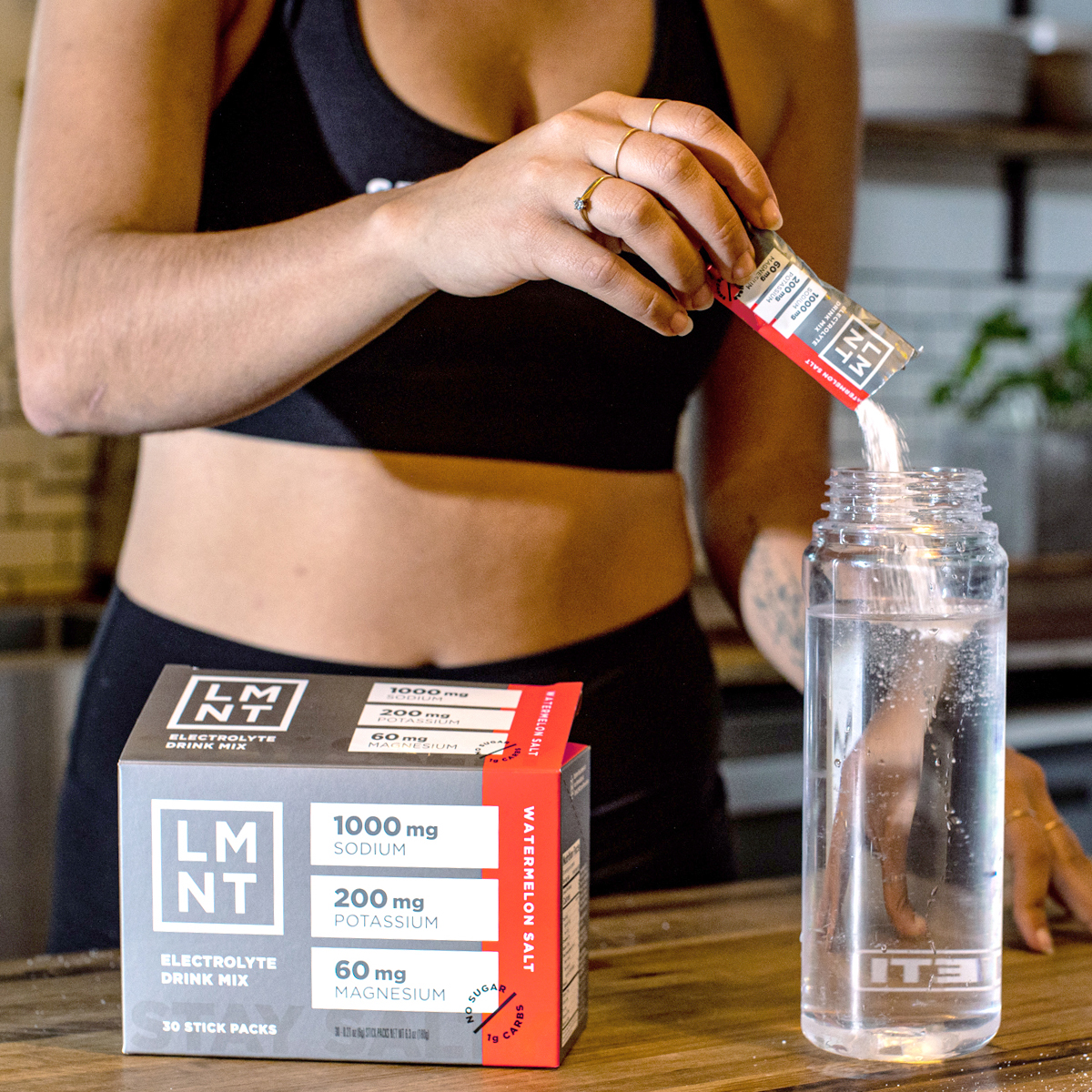 LMNT Citrus Salt drink mix and yellow 'Stay Salty' bottle on gym bench.