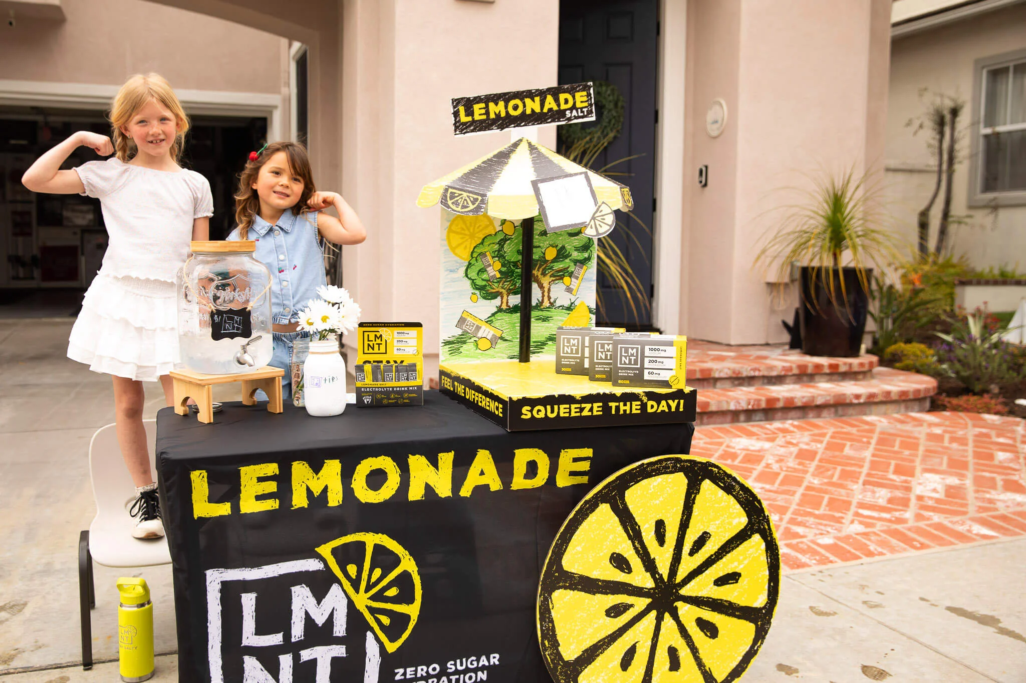 Kids posing next to LMNT's Lemonade Stand