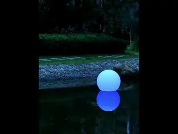 Multiple glowing solar LED balls floating on water creating mesmerizing reflections