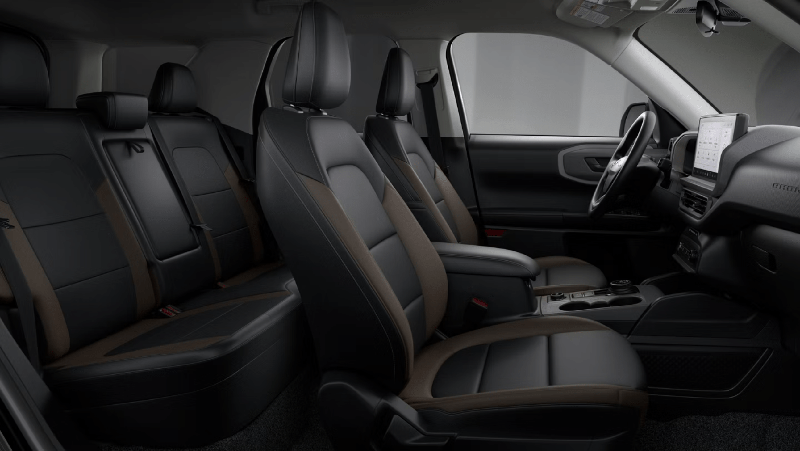 Black and brown leather seats in the foreground with dashboard and steering wheel in the background.