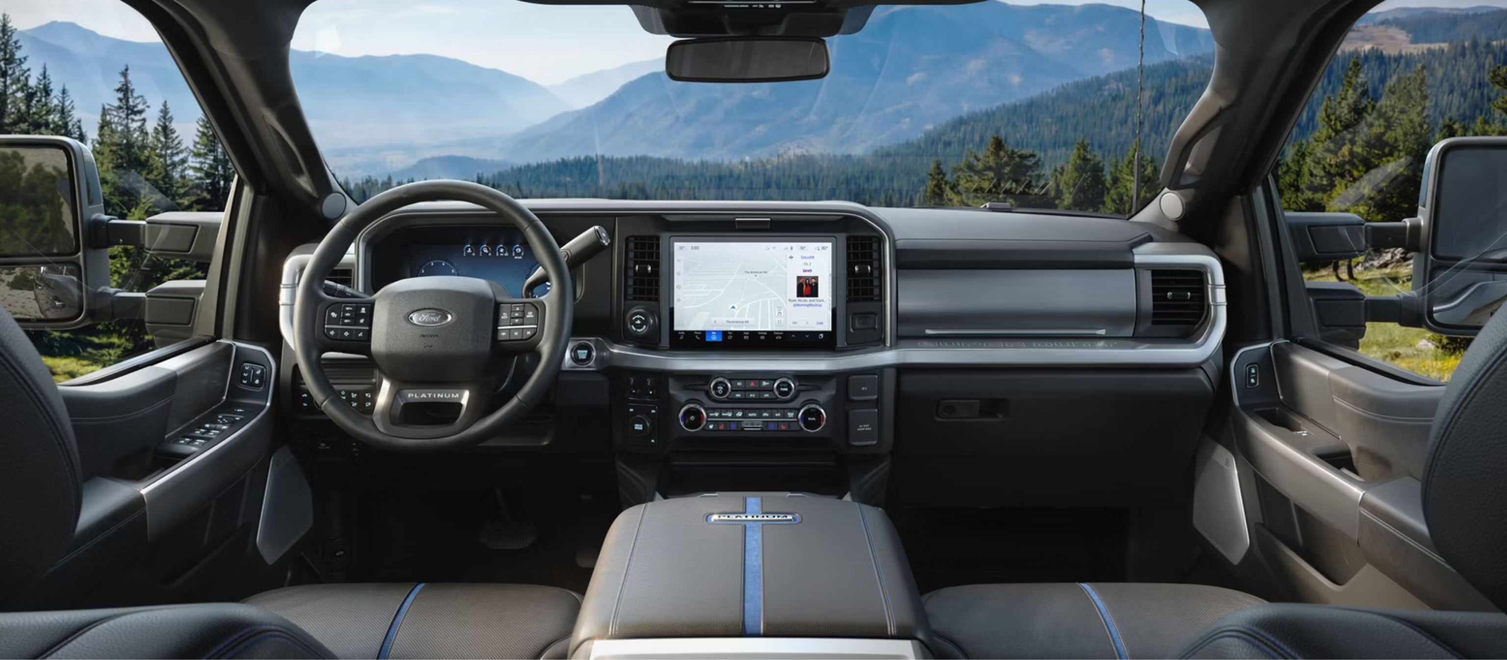 Modern truck interior with scenic mountain view through windshield in the background.