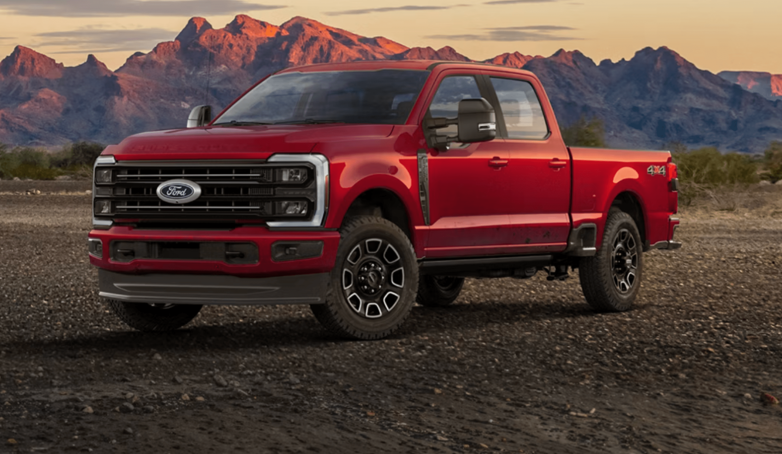 Red pickup truck on mountainous backdrop