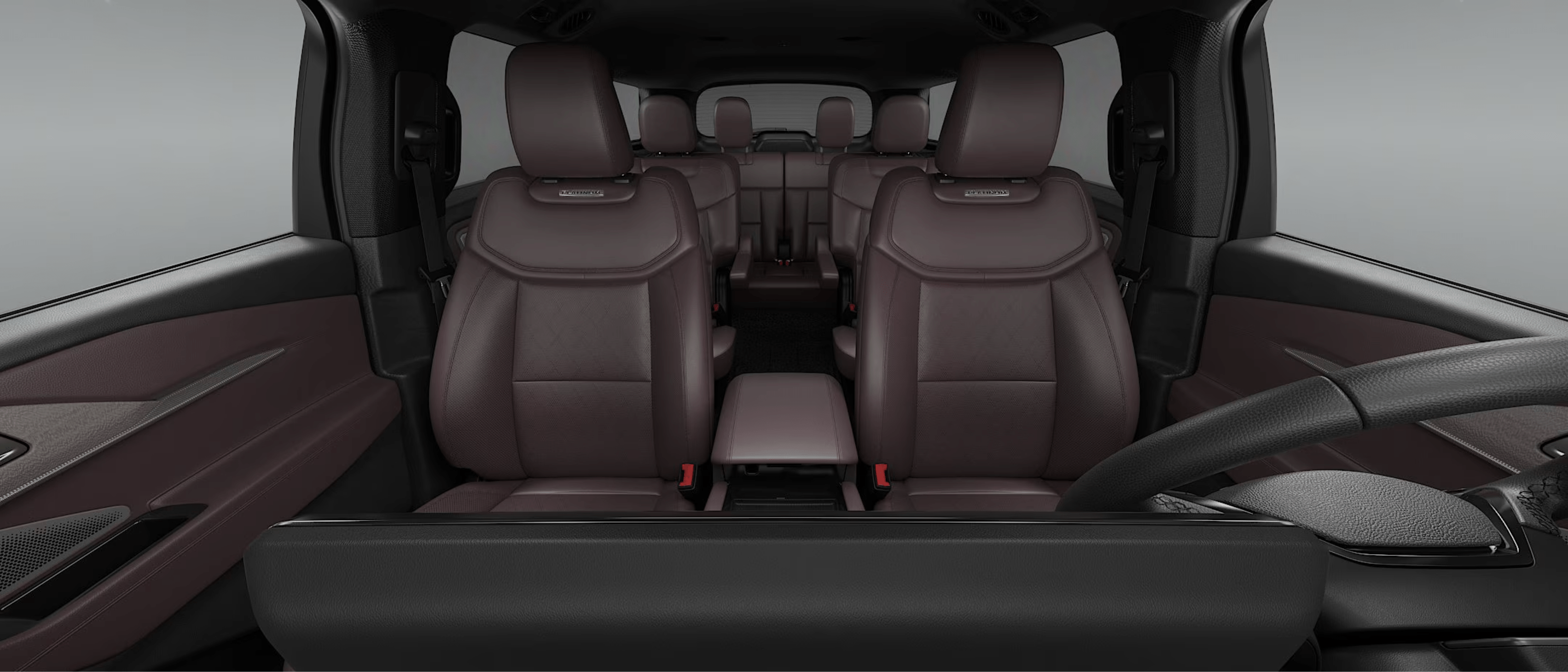 Brown leather front seats in a spacious vehicle interior with additional seating rows visible.