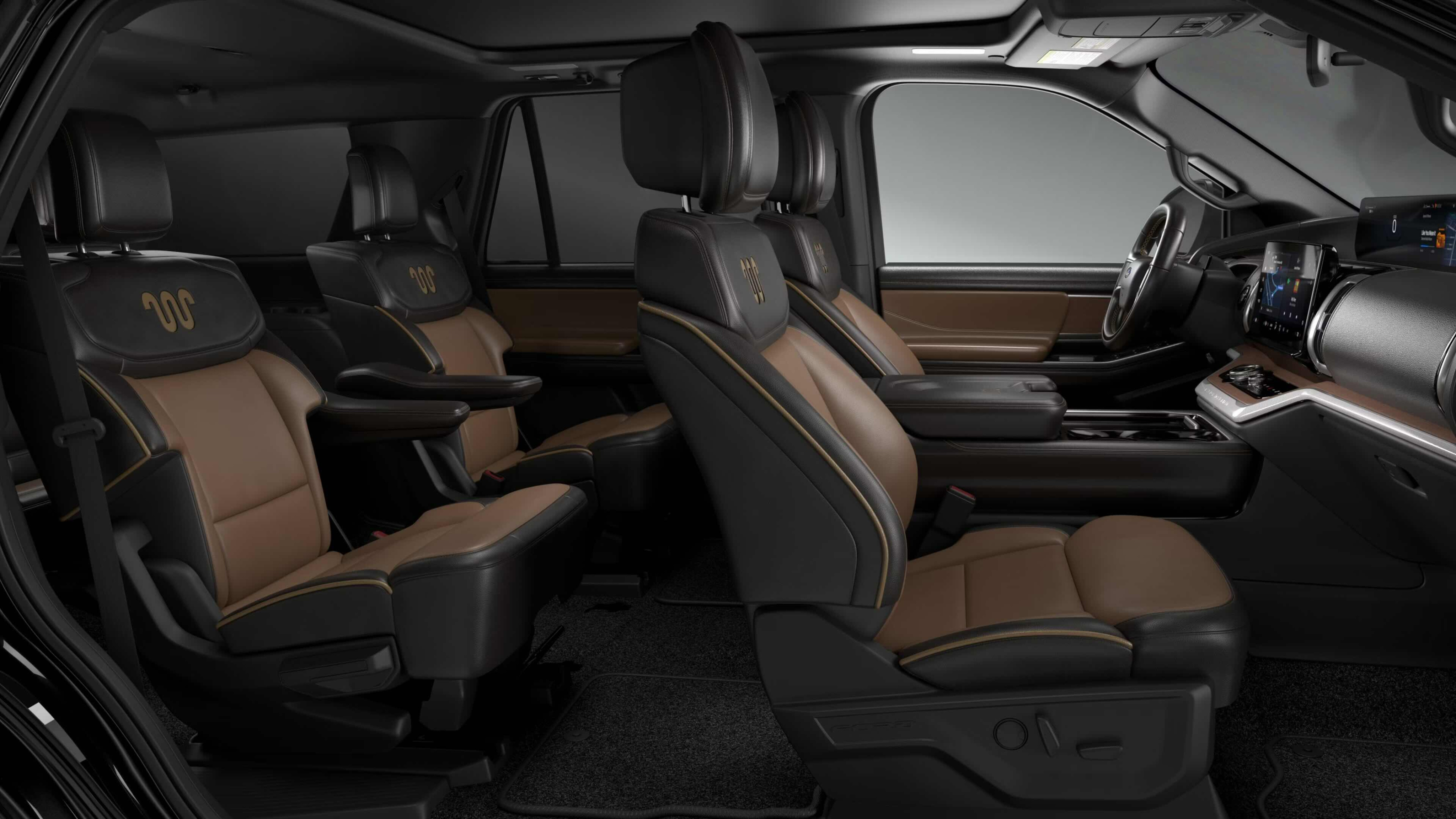 Brown and black leather seats with gold accents and dashboard with steering wheel in the background.