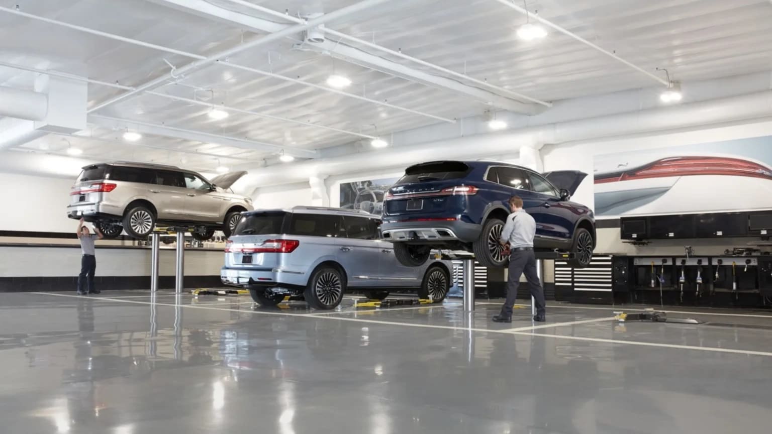 Vehicles being serviced on lifts inside a J.C. Lewis service facility