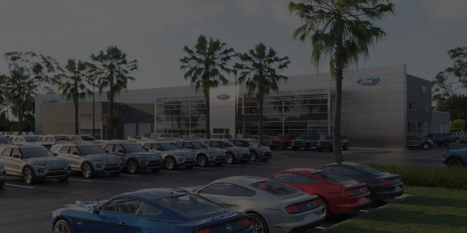 a group of cars parked in front of a ford dealership with palm trees in the foreground and a building in the background