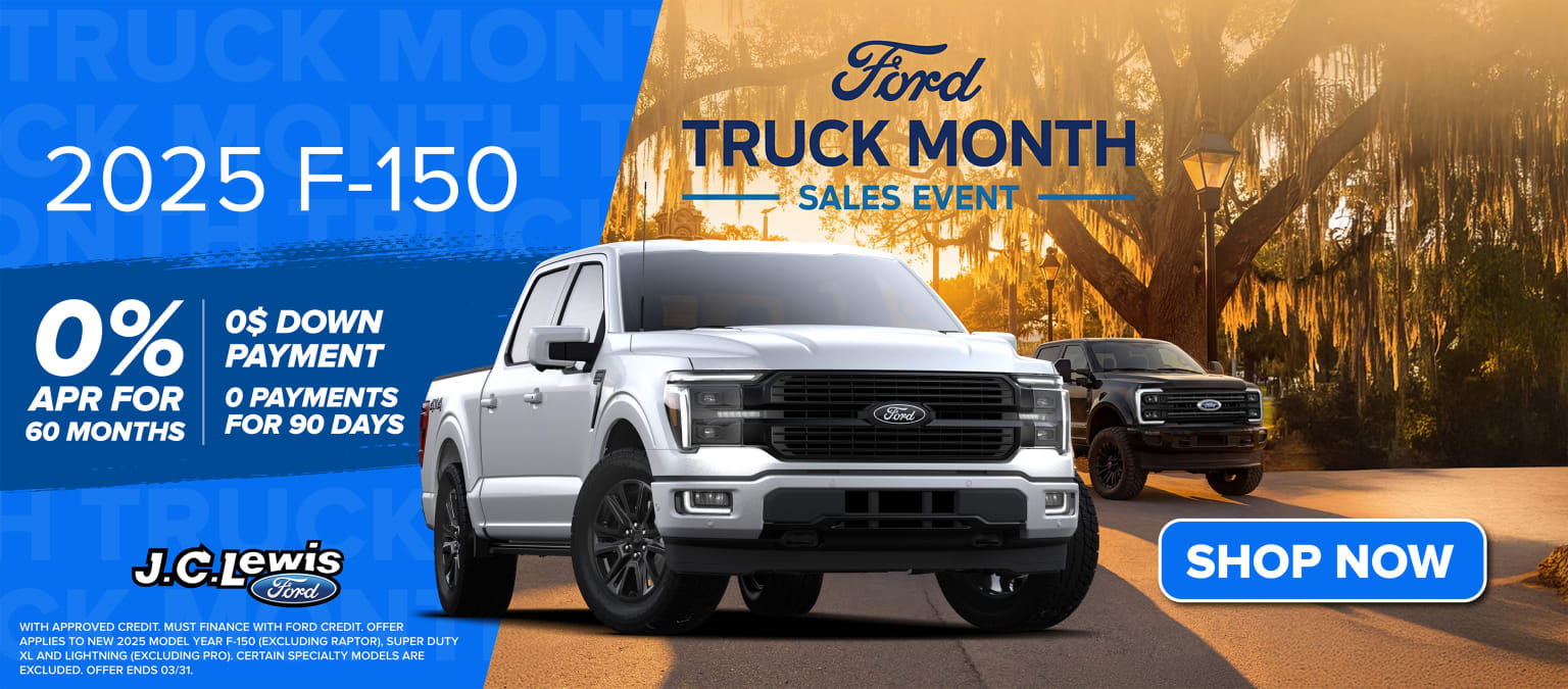 The image displays a pickup truck prominently showcased in the foreground, with a promotional banner for a truck sales event in the background, set against a scenic landscape.