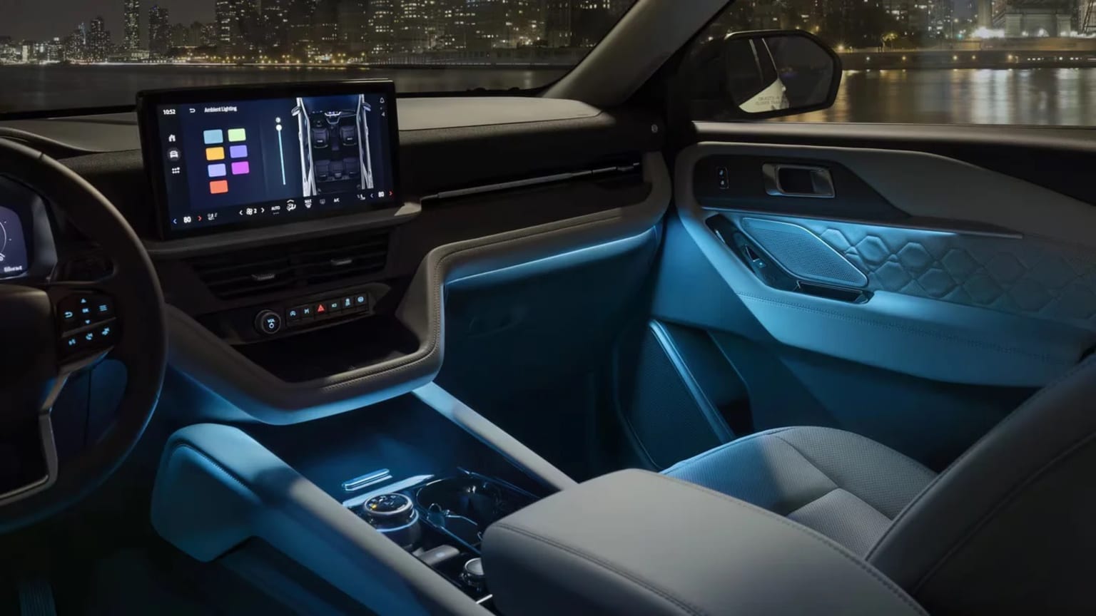 Interior of a modern, high-tech 2025 Ford Explorer with a large touchscreen display, sleek dashboard design, and ambient lighting accents in the door panels.