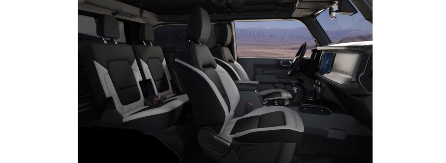 The image depicts the interior of a vehicle, showcasing rows of seats and a dashboard in the foreground, with a scenic landscape visible through the windshield in the background.