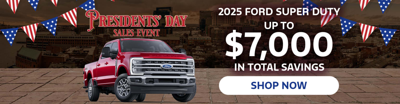 A red pickup truck is prominently displayed in the foreground, with a city skyline visible in the background. The image advertises a Presidents' Day sales event offering up to $7,000 in total savings on the 2025 model.
