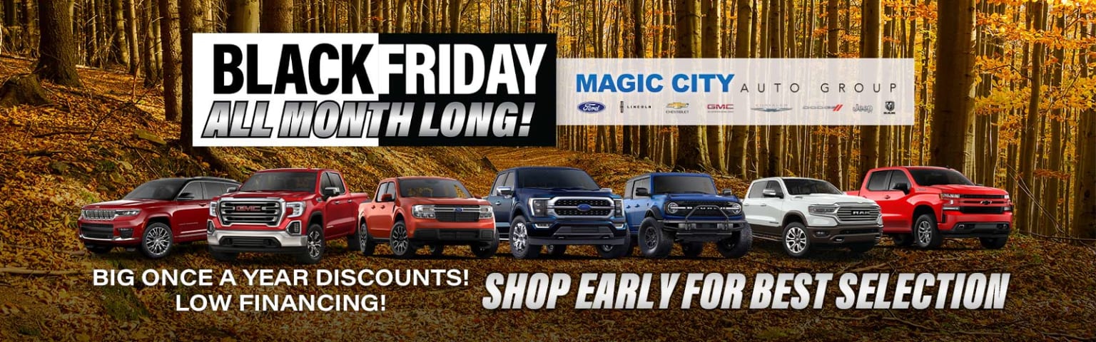 "Black Friday All Month Long!" promotion at a car dealership showcasing pickup trucks and SUVs against a wooden fence background.