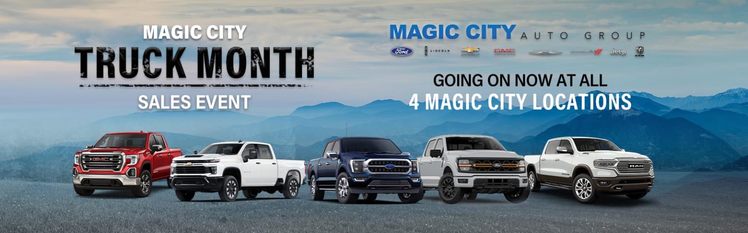 Several pickup trucks in a dealership lot with a mountainous background scenery.