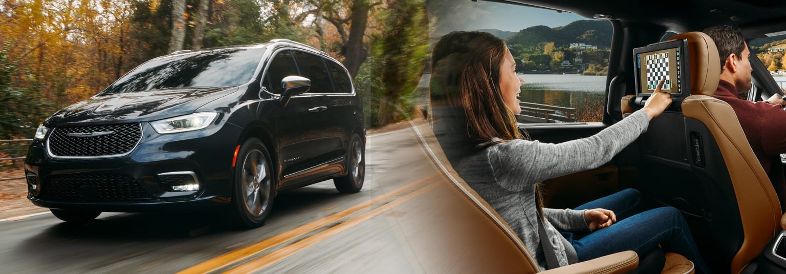 a woman driving a black minivan on a road next to a lake and a black minivan on the road