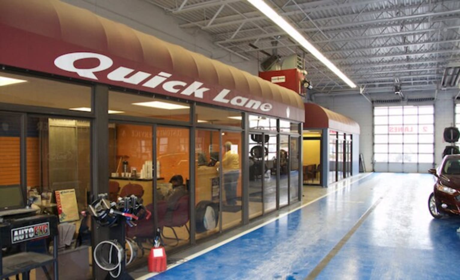 a car parked inside of a garage next to a building with a sign that says quick land on it