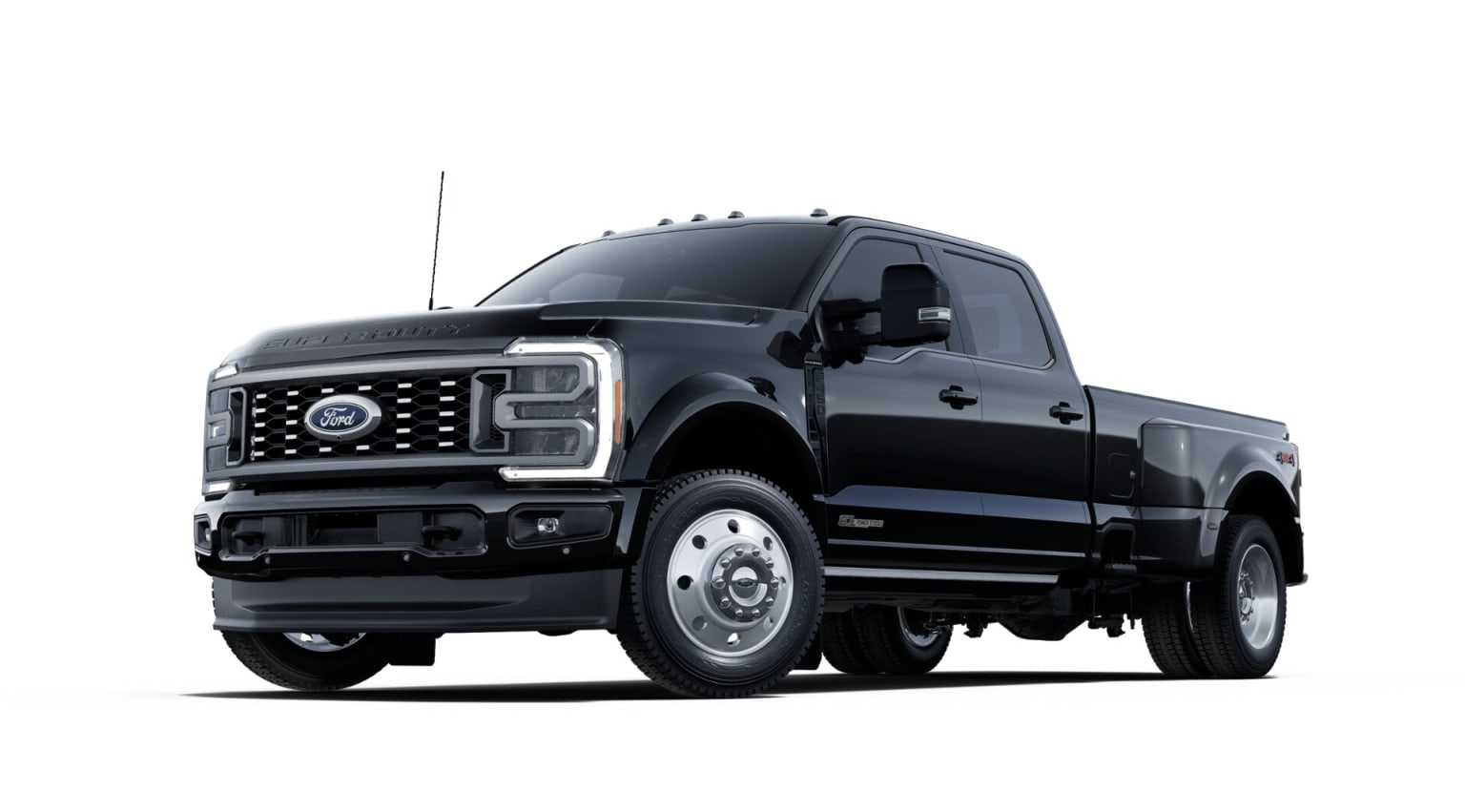 A large, black, heavy-duty pickup truck with a prominent grille and headlights stands prominently in the foreground against a plain white background.