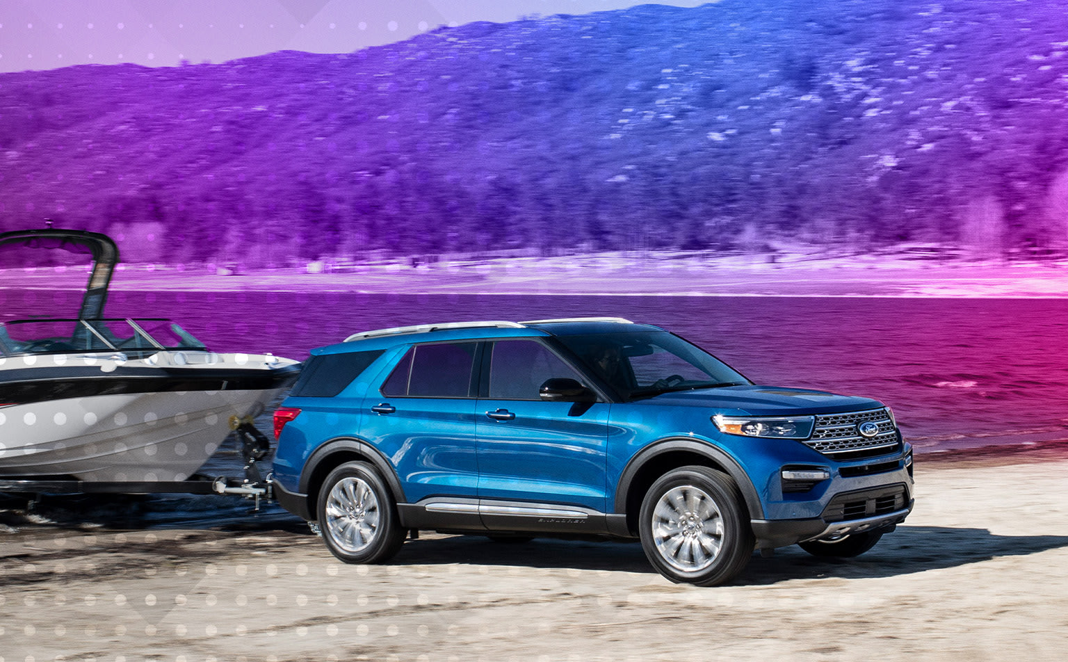 Blue SUV with boat trailer parked on a snowy shore with mountainous purple landscape in the background.