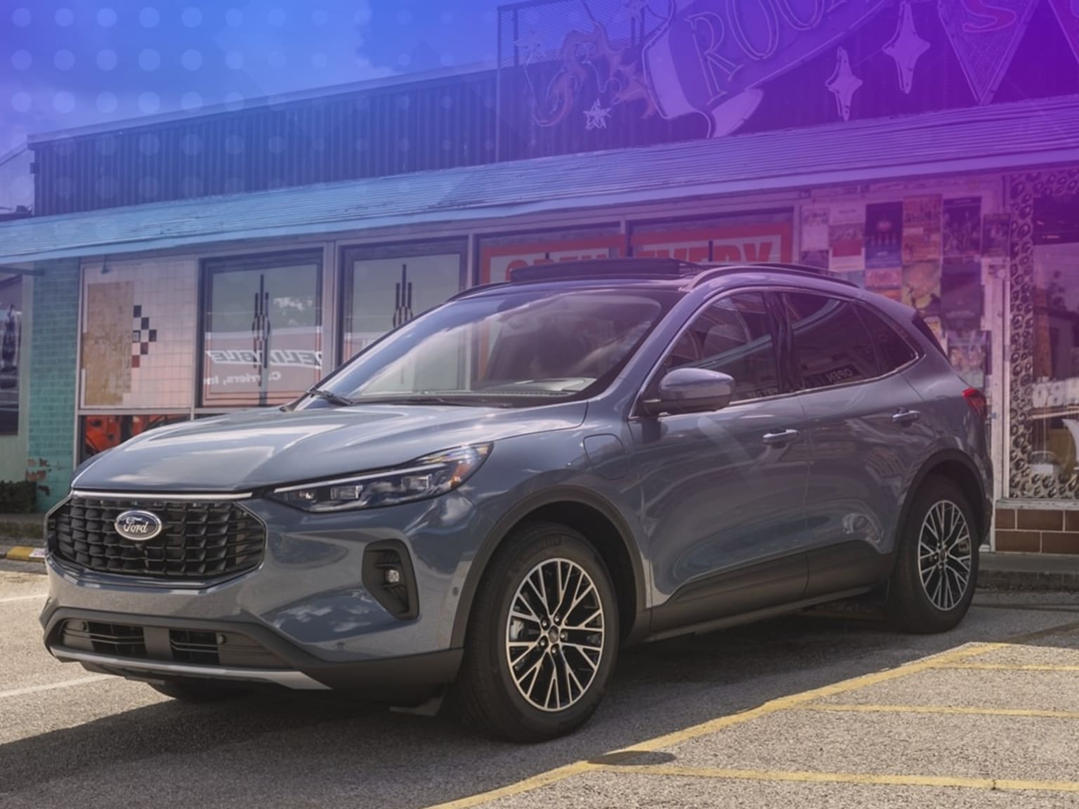 Modern gray SUV parked in front of a neon-lit building.