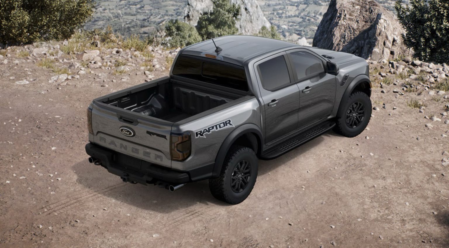 Off-road pickup truck parked on a dirt path, surrounded by rocky terrain and lush vegetation in the background.