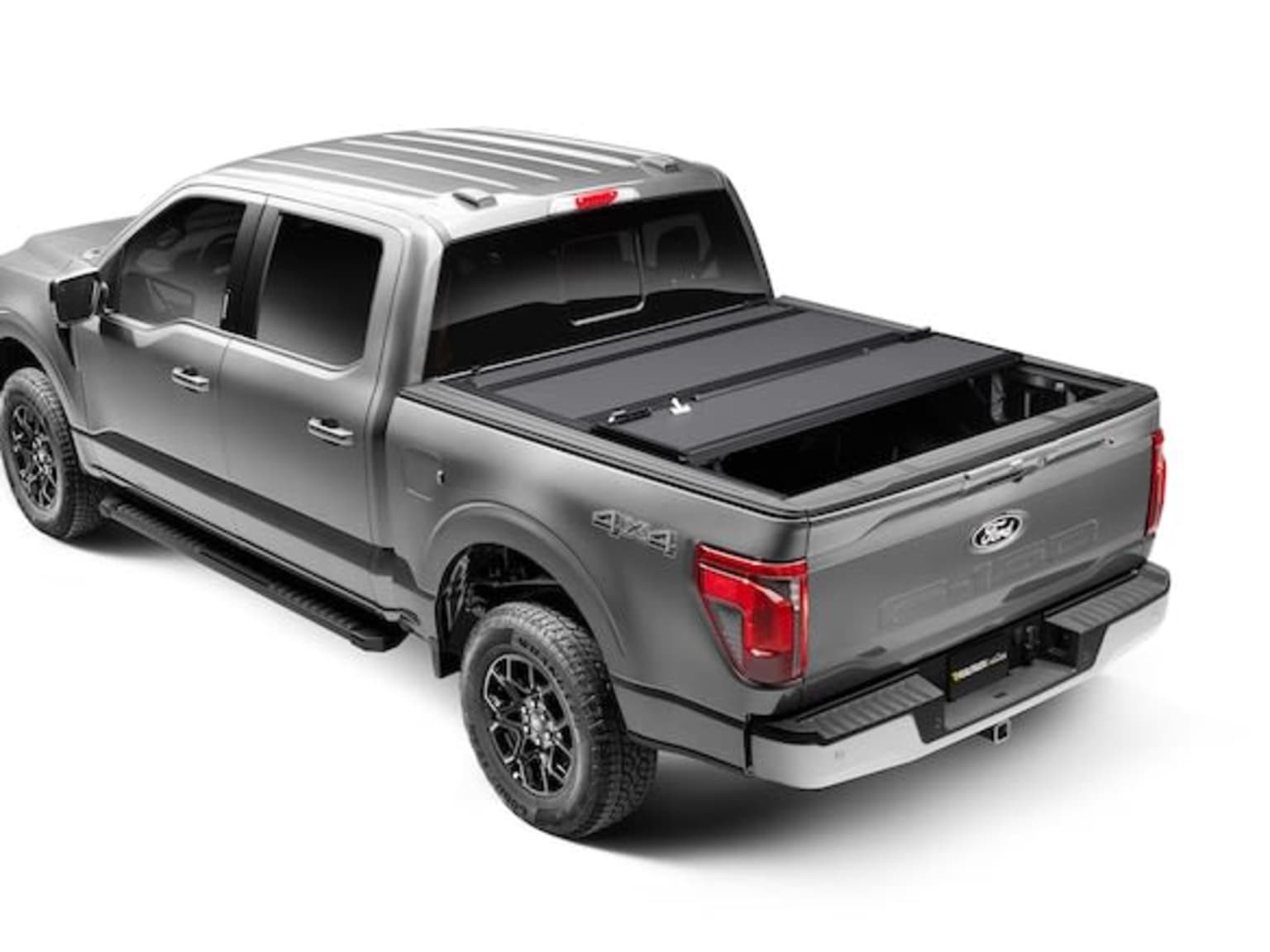 Silver pickup truck with tonneau cover parked outdoors.