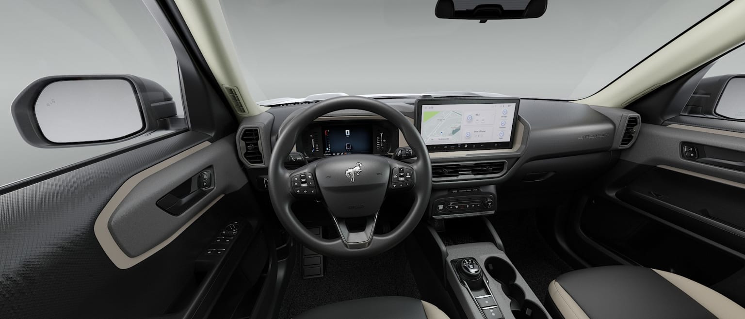 Interior of a car featuring a steering wheel and dashboard against a plain white studio background.